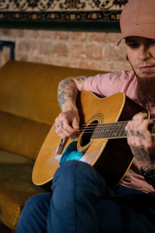 bezplatná Základová fotografie zdarma na téma akustická kytara, chlap v tetování, hráč na kytaru Základová fotografie