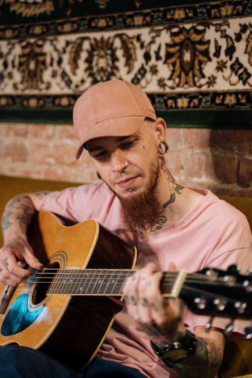 Man in Pink Shirt Playing Acoustic Guitar