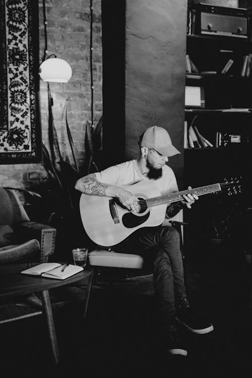 Grayscale Photo of a Man Playing Acoustic Guitar