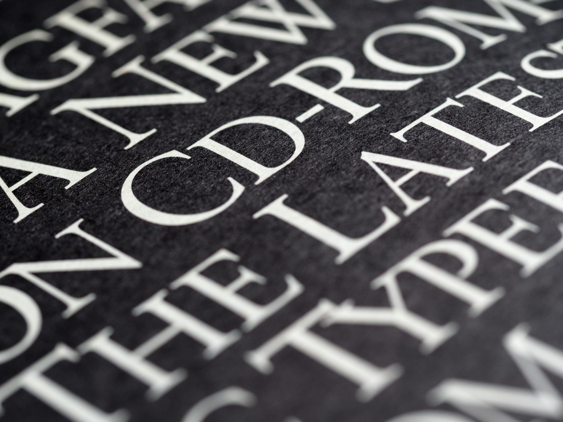 Detailed close-up of white text printed on black paper, showcasing typography.