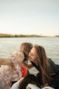 两名女子在宁静的湖边幸福相拥，捕捉到了夏日友谊的精髓