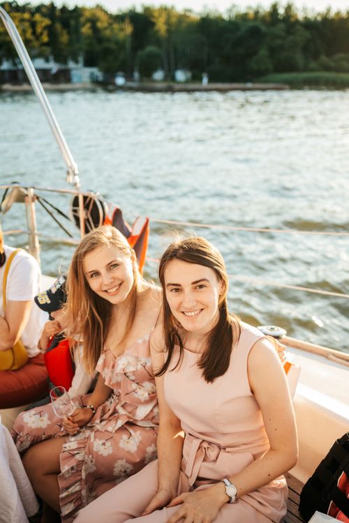 Free Two women smiling and enjoying a sunny day cruise on a yacht, capturing joy and friendship. Stock Photo