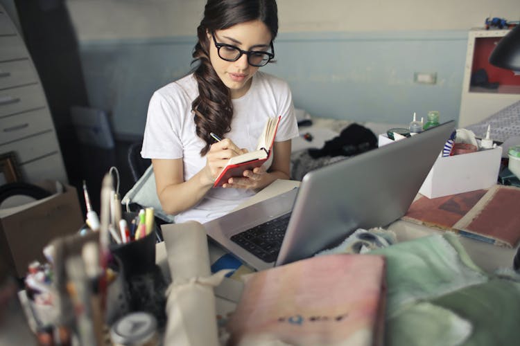 Woman Working From Home By Messy Desk