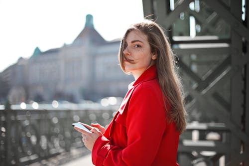 Woman in Red Long Sleeve Shirt Holding Smartphone