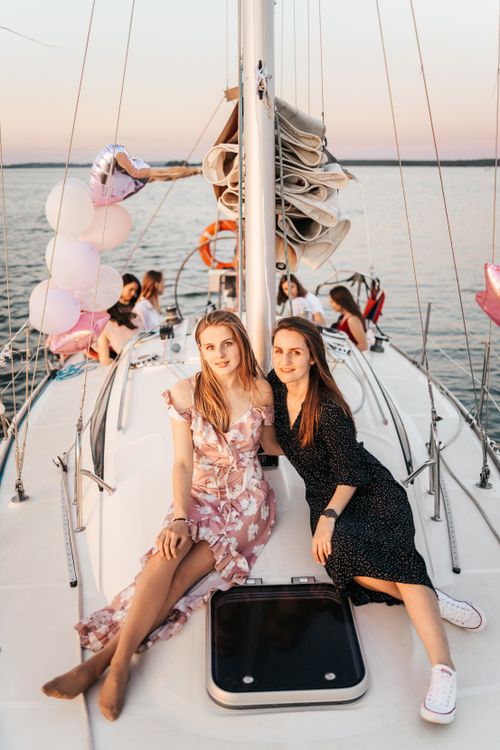 Free Young women enjoying a serene yacht party at sunset, capturing joyous moments. Stock Photo