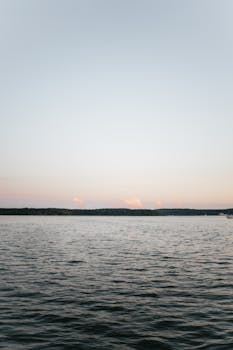 Peaceful ocean view at sunset with calm waters and a serene sky.