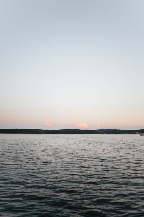 Free Peaceful ocean view at sunset with calm waters and a serene sky. Stock Photo