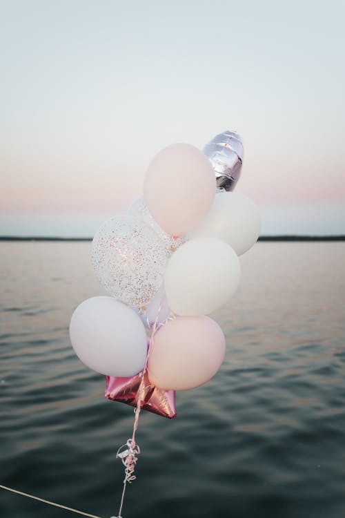 A Set of Balloons Tied Near Body of Water