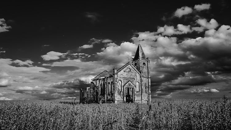 Abandoned Church In Field Under Cloudy Sky