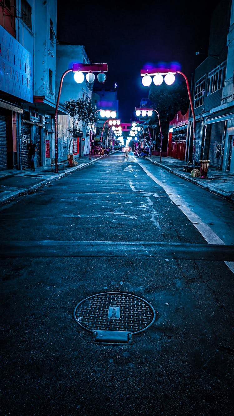 Empty City Road Illuminated By Shiny Lights At Night