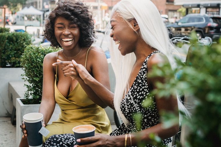 Two friends laughing on a city street, photo by Ketut Subiyanto on Pexels