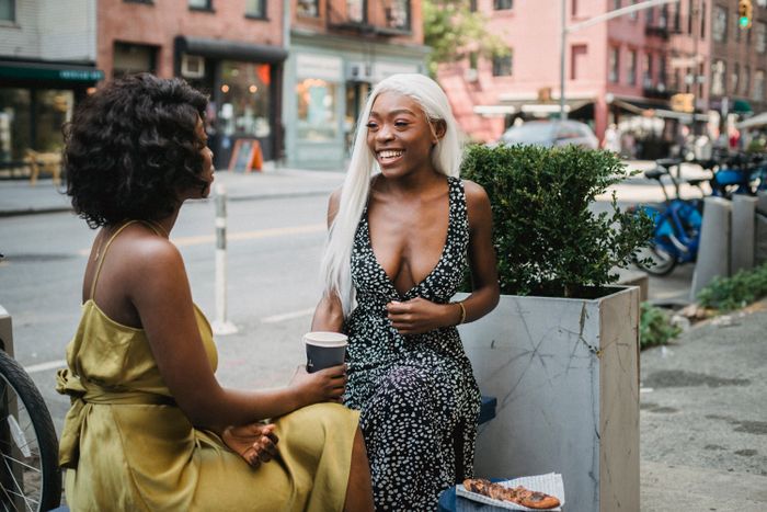 Two women deep in conversation at an outdoor cafe. Photo by Ketut Subiyanto on Pexels