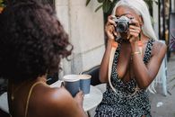Woman in Black and White Tank Top Holding Black Dslr Camera