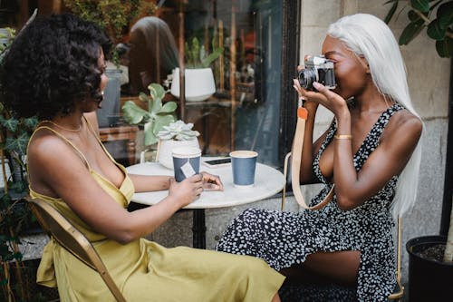 Woman Taking Photo of Another Woman with a Camera