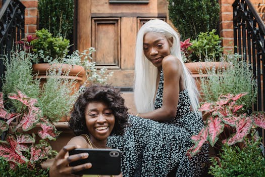 两个快乐的女人在绿树成荫的舒适家中自拍