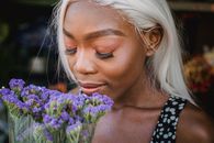 Woman in Black and White Polka Dot Top Holding Purple Flower Bouquet