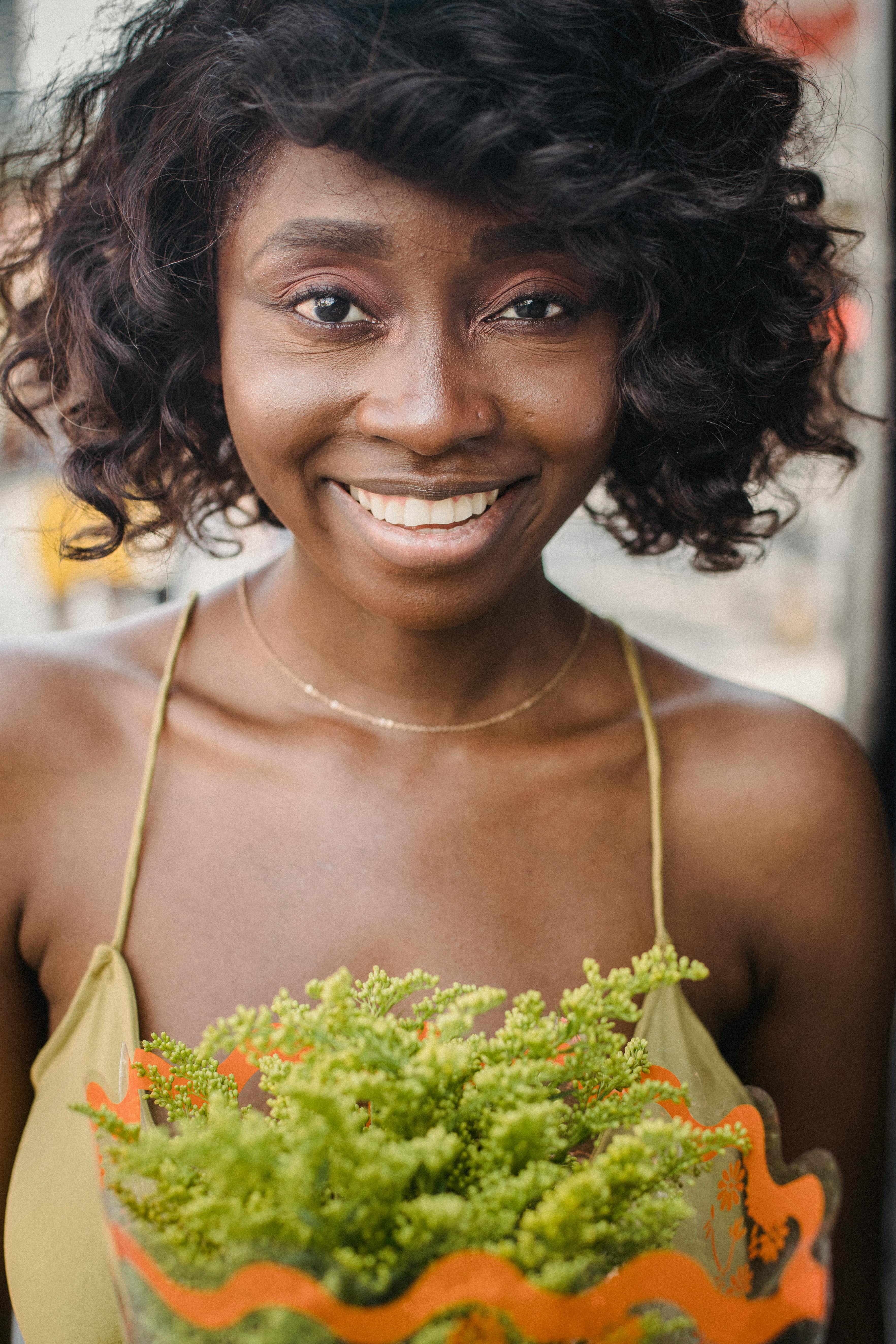 Woman in Yellow Spaghetti Strap Top Holding Green Flower Bouquet