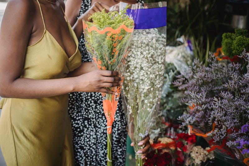 Two women choosing delicate flower bouquets at a charming flower shop.