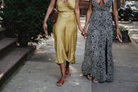 Woman in Black and White Floral Dress Standing Beside Woman in Yellow Dress