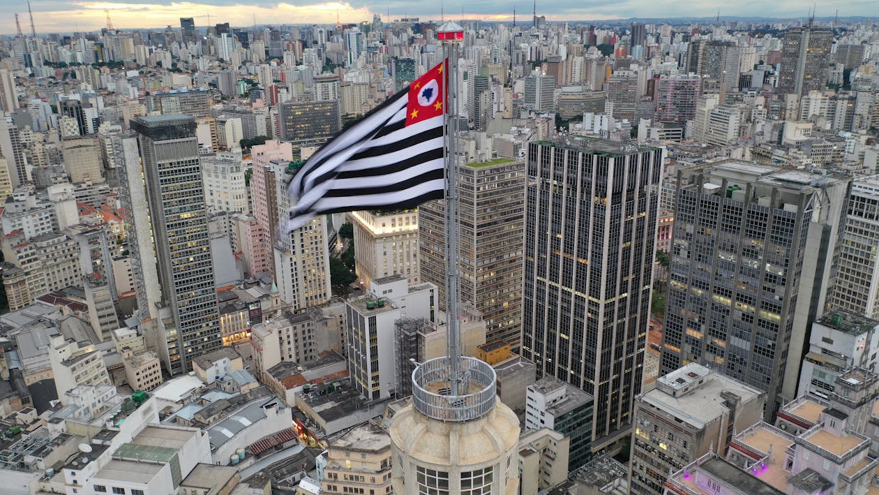 Free Aerial view of Sao Paolo flag waving on wind on skyscraper spire in urban metropolis district in daylight Stock Photo