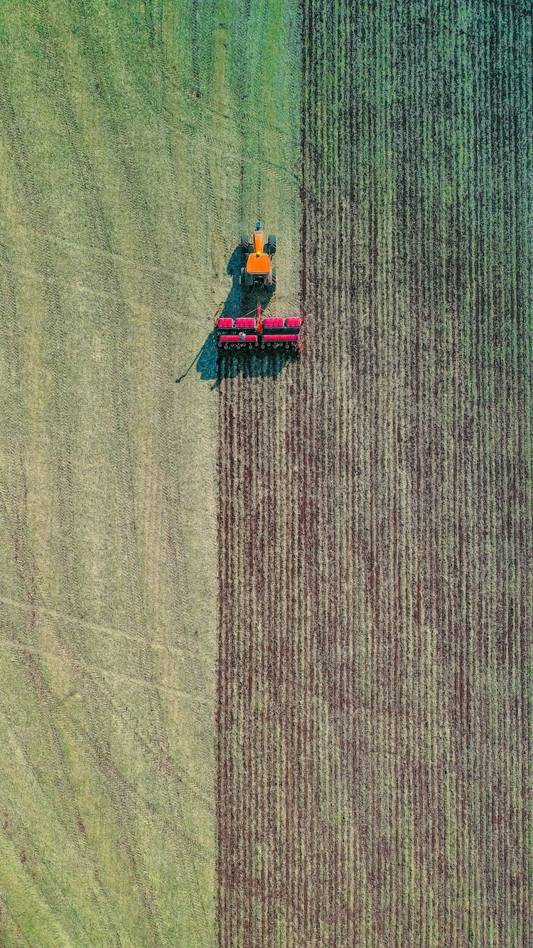 Modern Tractor Plowing Green Field