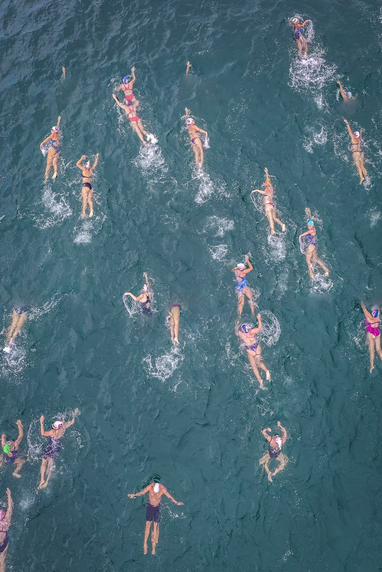 People Swimming In Sea During Competition