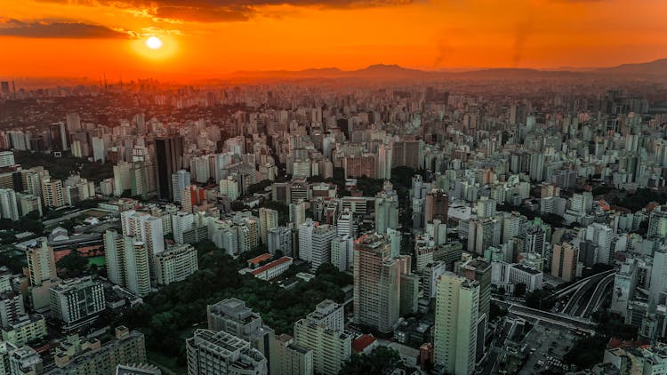 Modern City Under Bright Colorful Sky At Sunrise