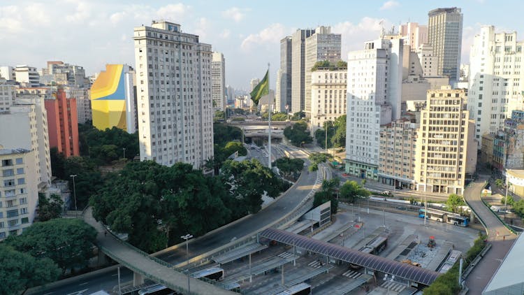 Modern City With Bus Station Near Buildings And Trees