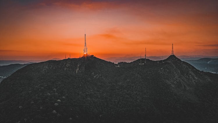 Telecommunication Towers In Hills In Orange Sunset