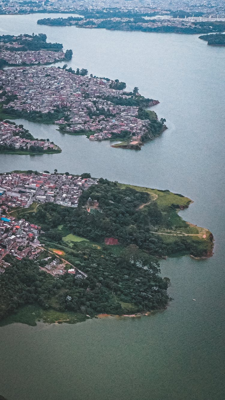 Peninsula With Houses And Trees Washed By River