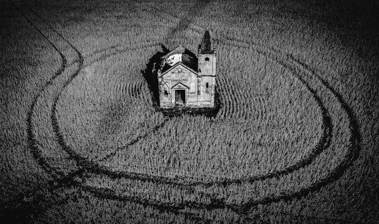 Small Damaged Church With Cross In Field