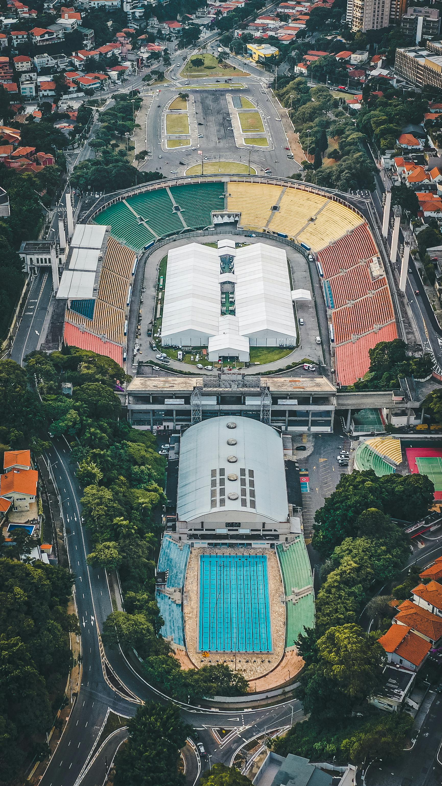 stadium in modern city surrounded by houses and green trees