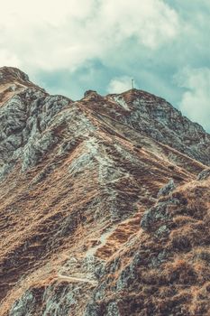 Scenic view of a rugged mountain trail under a blue sky in Tirol, Austria.