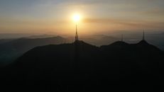 Picturesque scenery of many TV towers located on vast hilly terrain beneath rising sun