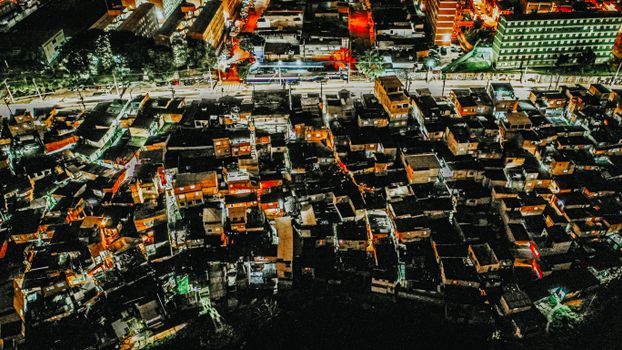 Aerial congested residential area with illuminated houses at night