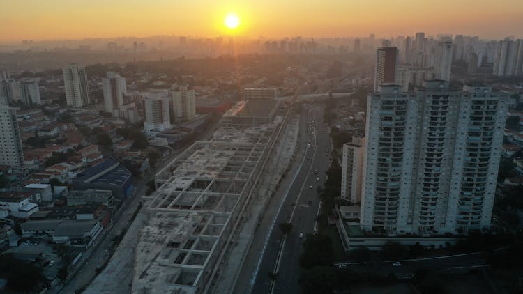 Cars Driving On Road Between Towers And Construction Site