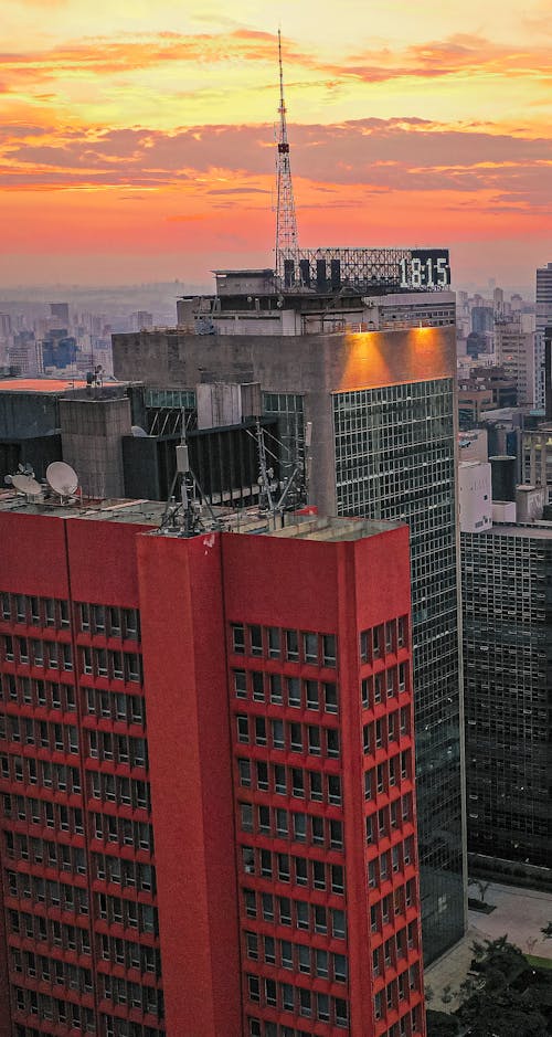 Free High skyscrapers located in modern megapolis district under colorful sunset sky with clouds at dusk Stock Photo