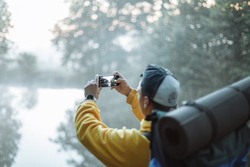Free Person in Yellow Jacket Taking Photo in the Forest Stock Photo
