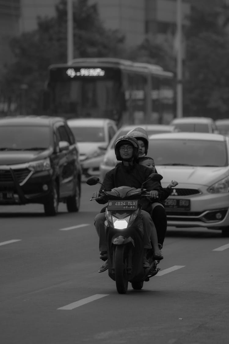 People Riding On A Scooter In A City 