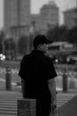 Man in Black Shirt and Black Cap Standing on Sidewalk during Night Time