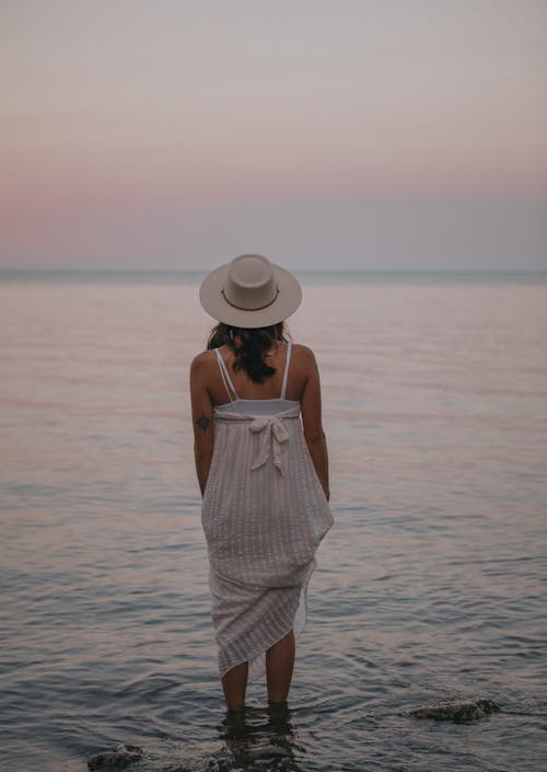 Romantic woman standing in water of sea