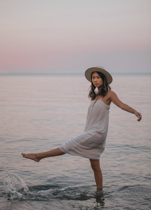 Serene ethnic woman splashing water in sea