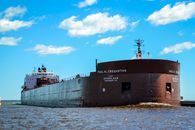 Black Ship on Sea Under Blue Sky and White Clouds
