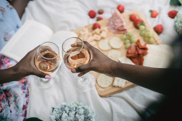 Close-up Of Women Cheers With Glasses On Picnic