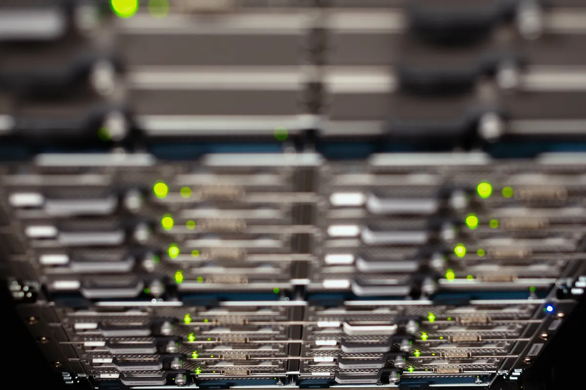 A close-up of stacked server blades in a rack with green status lights, representing the hosted infrastructure that receives a TradingView webhook and forwards the order to a broker.