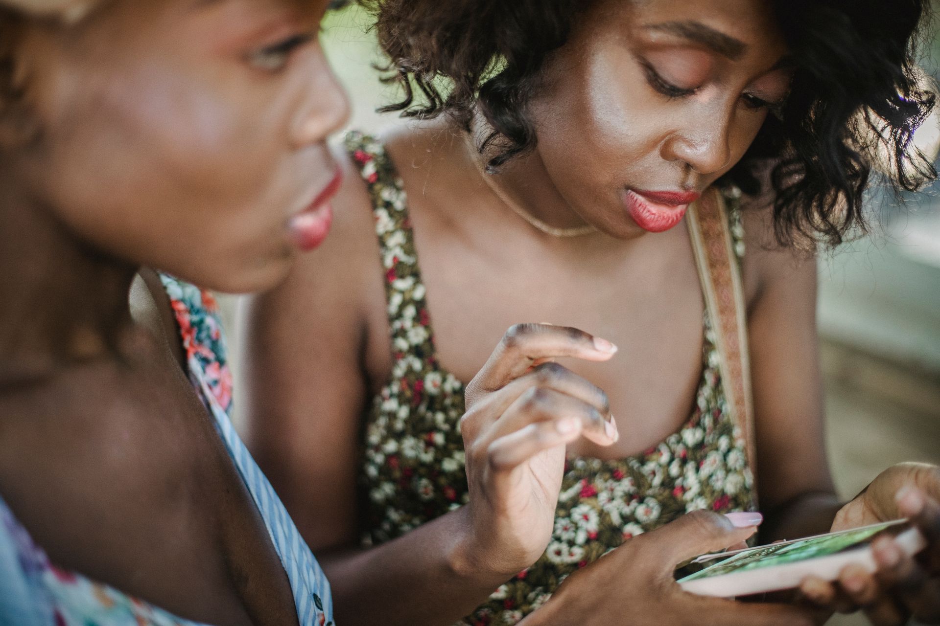 Women in Floral Dress Looking at the Smartphone Together