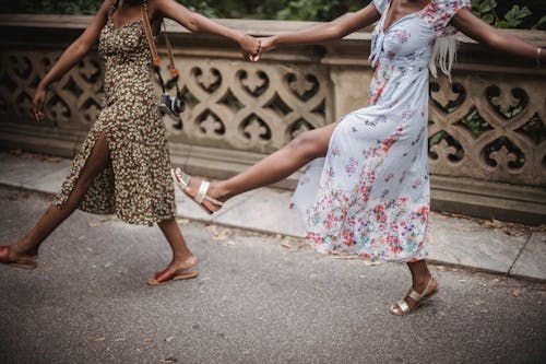 Women in Floral Dress Dancing Together
