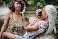 两名女子在公园里大笑，享受着户外摄影的乐趣