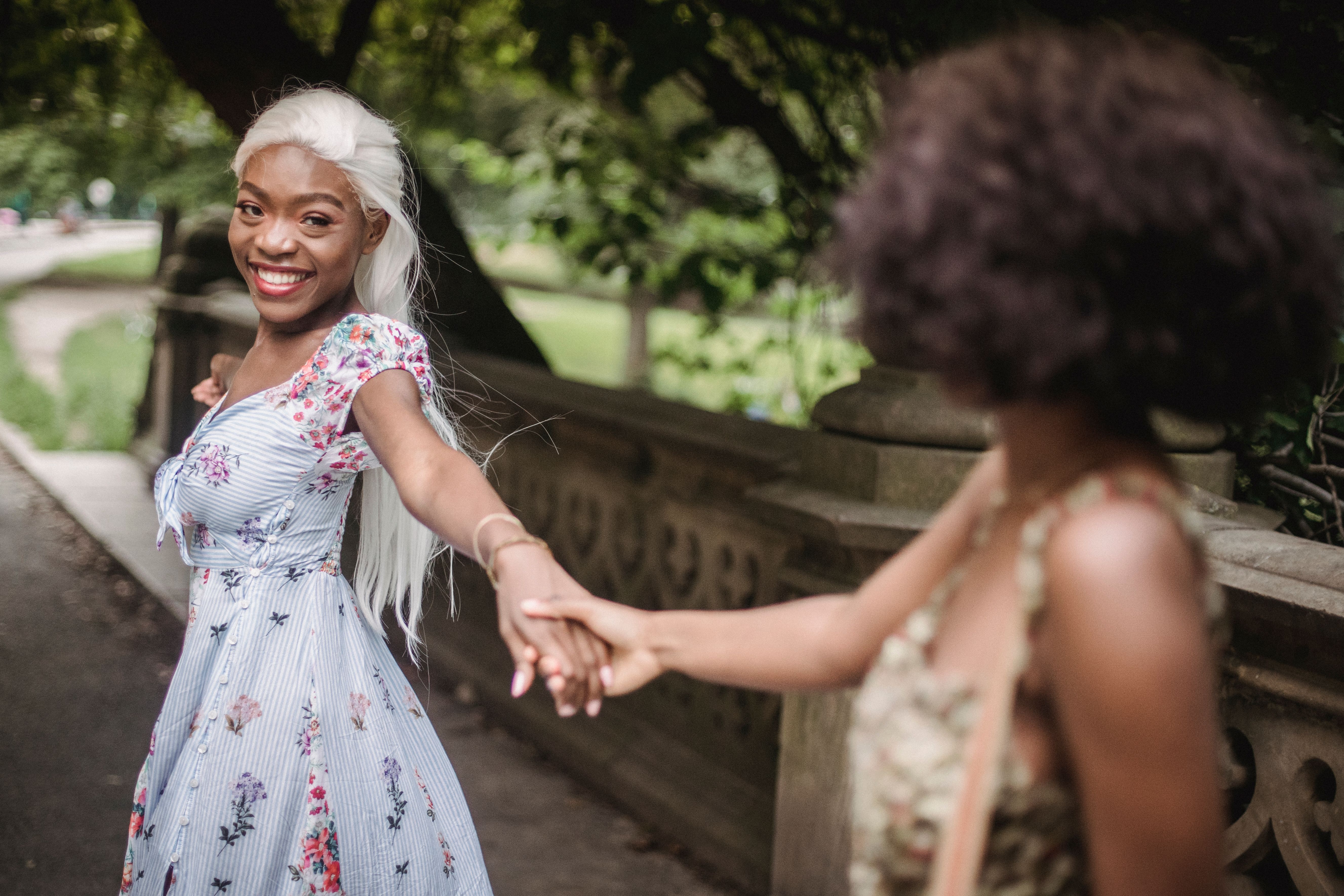 Women in Floral Dress Holding Hands and Looking at Each Other · Free ...
