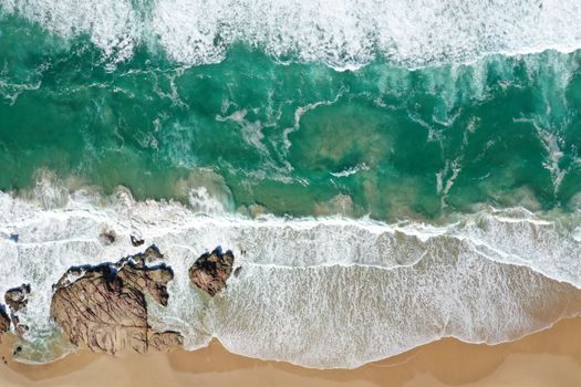 A stunning aerial view of Camden Head beach showcasing vibrant waves crashing on the shore.